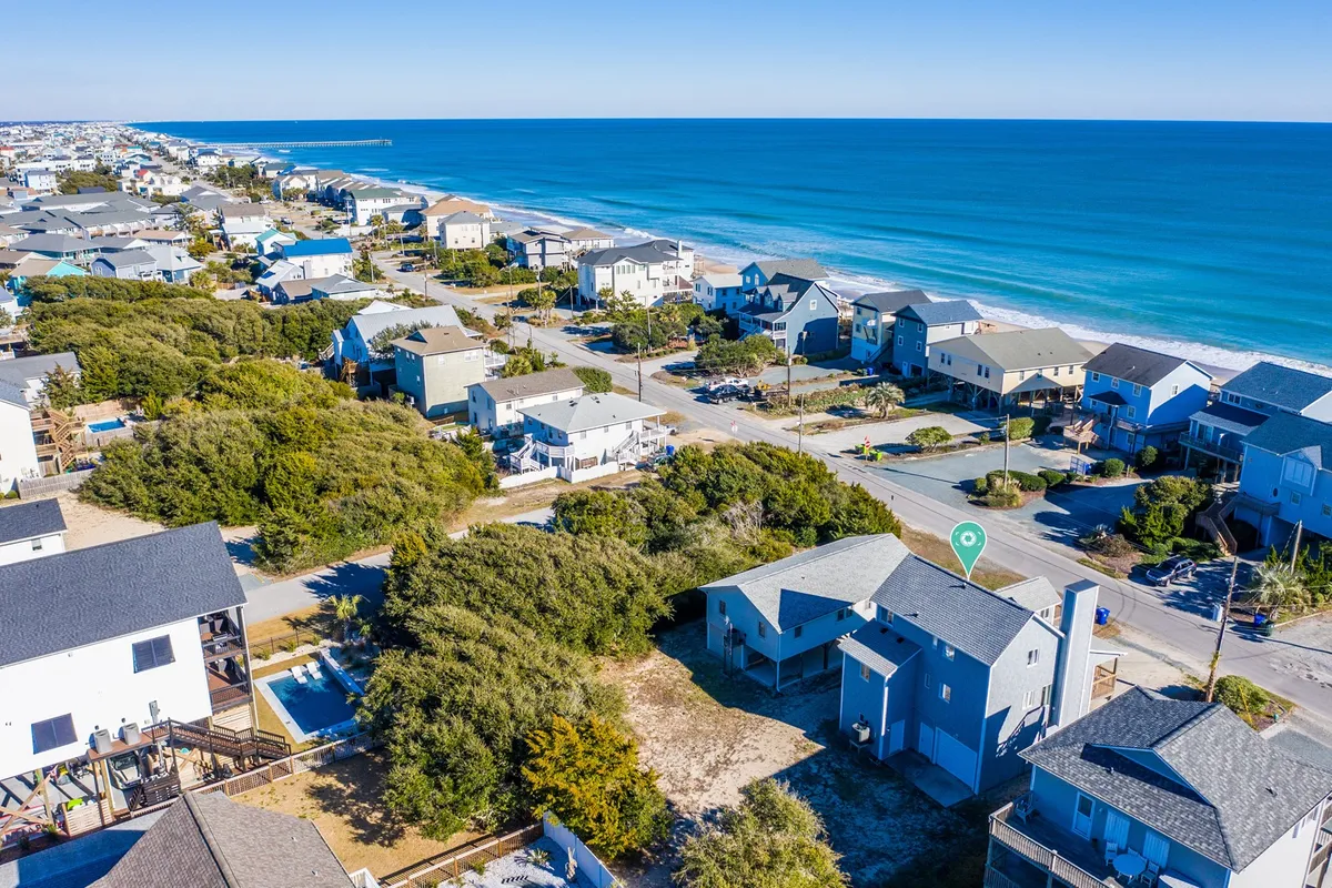 A panoramic exterior view showing the ocean, sandy beach, and a line of beachfront properties. The layout captures the essence of Surf City's relaxed neighborhood, with homes positioned to take full advantage of the coastal atmosphere. The image resonates with the activities mentioned, such as beachcombing and water sports, while highlighting easy access to the boardwalk and local attractions.